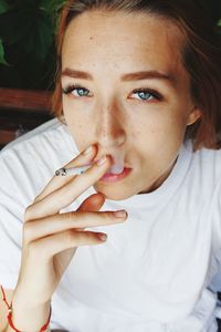 Close-up portrait of beautiful woman smoking cigarette