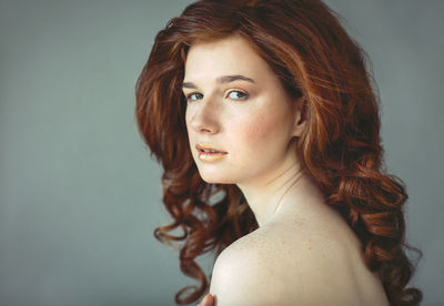 Portrait of a beautiful young woman over gray background