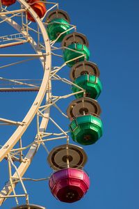 Low angle view of ferris wheel against clear blue sky