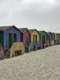 Beach huts by the coast against sky