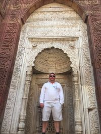 Low angle portrait of man standing against building