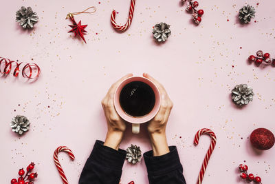 Directly above shot of woman holding coffee cup on table