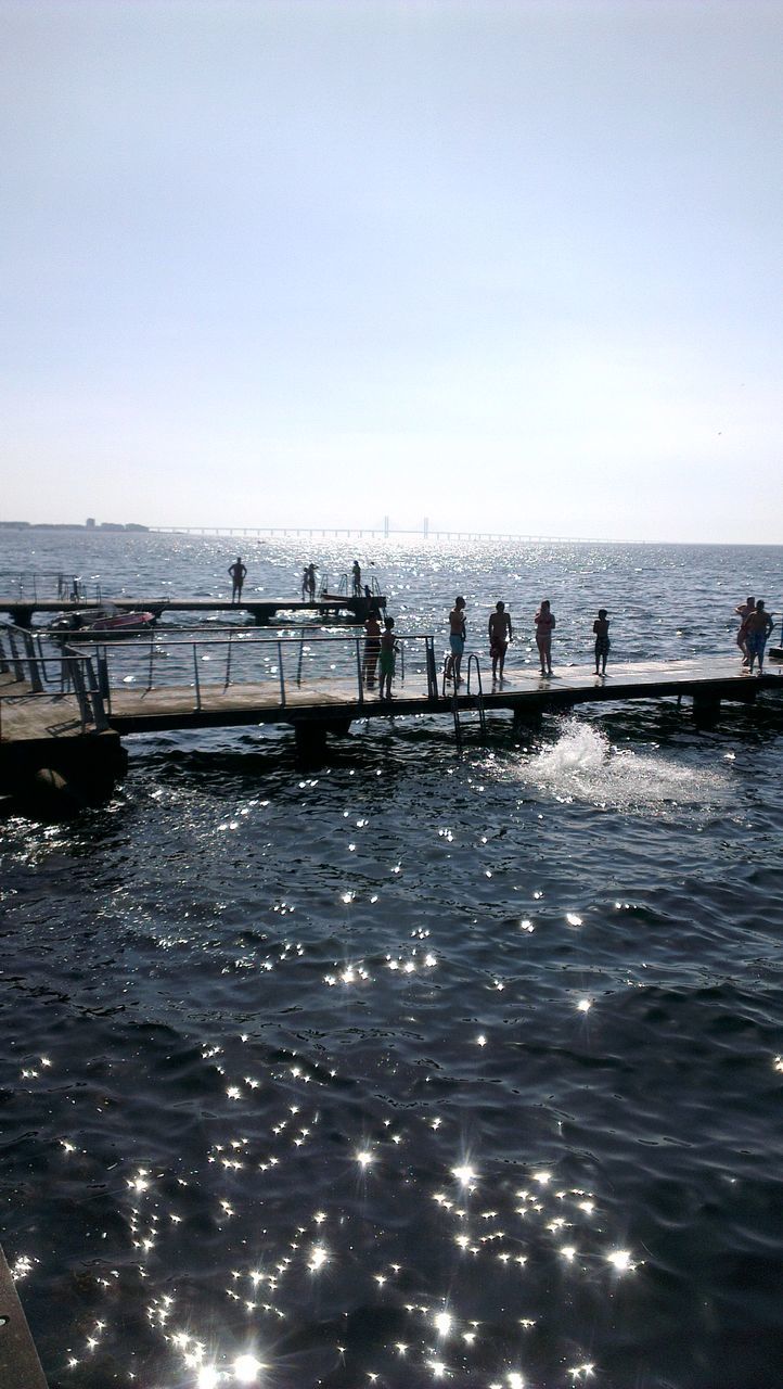 water, sea, horizon over water, waterfront, clear sky, large group of people, scenics, pier, nature, tranquil scene, beach, rippled, sky, copy space, tranquility, leisure activity, beauty in nature, vacations, men