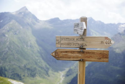 Information sign against mountain range against sky