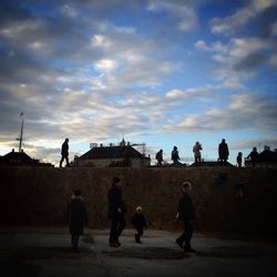 Silhouette of woman against cloudy sky