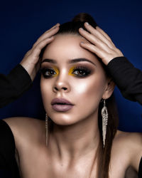 Close-up portrait of young woman against black background