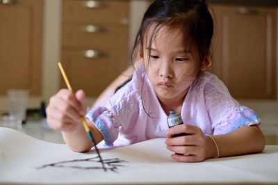 Girl holding paper at home