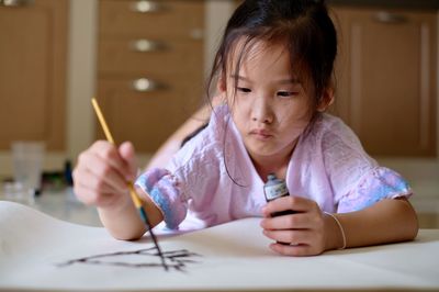 High angle view of girl painting on floor 