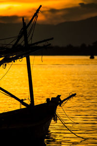 Silhouette sailboat on sea against sky during sunset