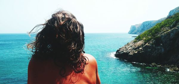 Rear view of woman looking at sea against sky