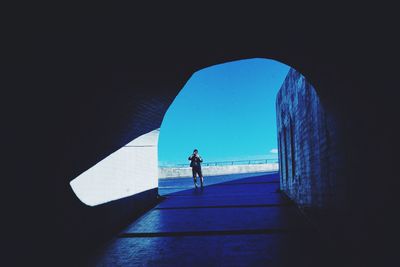 Man on street seen through tunnel