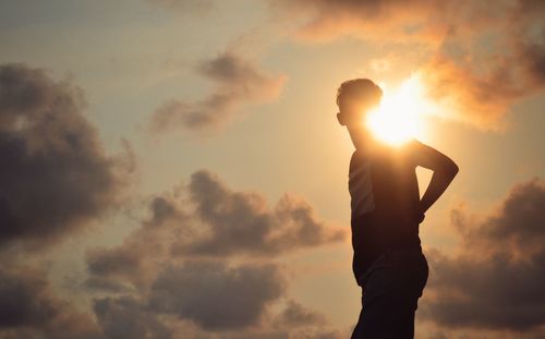 Low angle view of silhouette man standing against sky during sunset