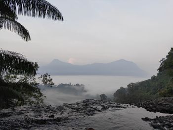 Scenic view of sea and mountains against sky