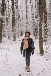 Portrait of woman standing on snow covered field