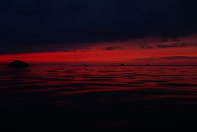 Scenic view of sea against dramatic sky during sunset