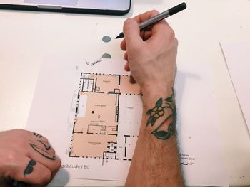 Cropped image of architect drawing plans at drawing board