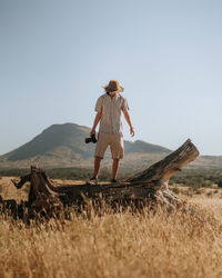 Person standing on a fallen tree stump in the savannah in africa