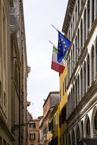 Low angle view of flags on buildings in city