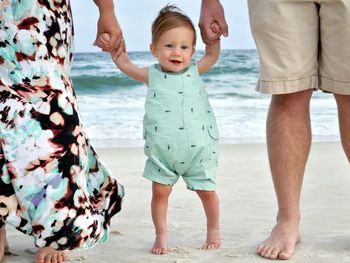 Portrait of father and son standing on beach