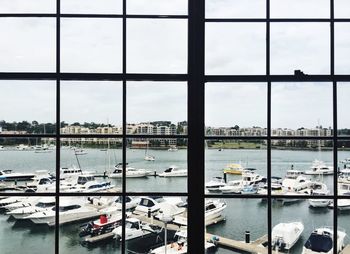 Sailboats in city seen through window