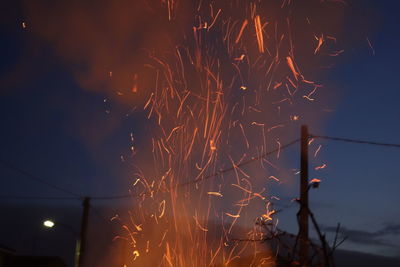 Firework display against sky at night