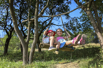 Full length of mother and daughter on tree