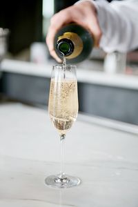 Cropped hand pouring champagne in glass