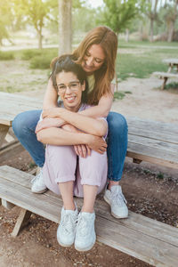 Portrait of young woman sitting on bench