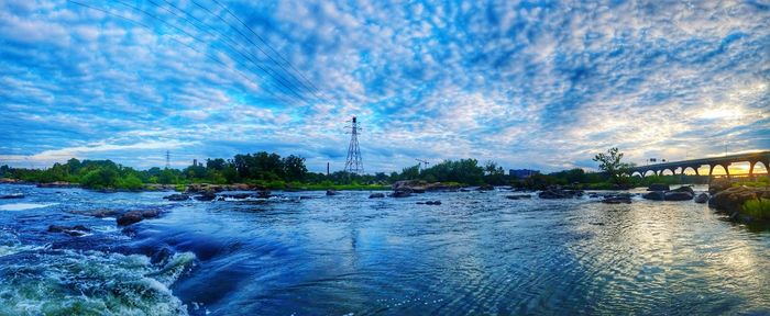 Scenic view of river against cloudy sky