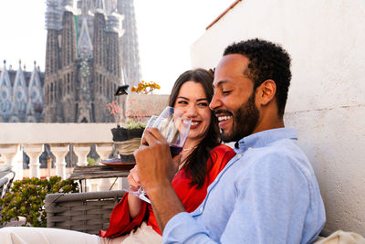 Side view of young woman drinking wine in city