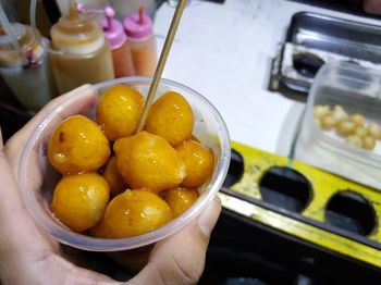 Close-up of hand holding fruits in bowl