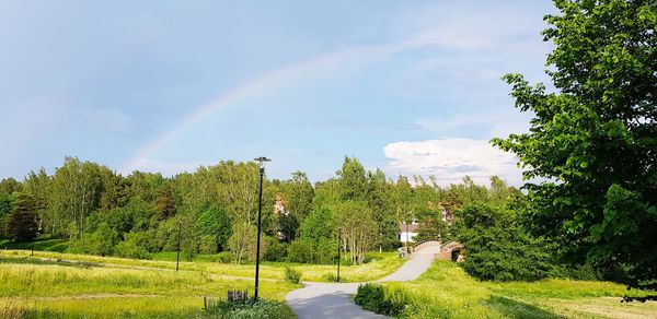 Scenic view of rainbow over landscape against sky