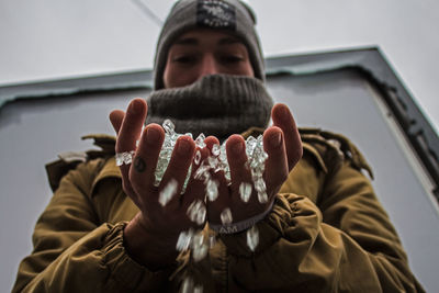 Low angle view of man holding glass beads