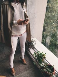 Cropped image of woman using phone