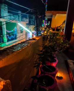 High angle view of illuminated street amidst buildings at night