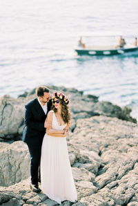 Rear view of couple standing at beach