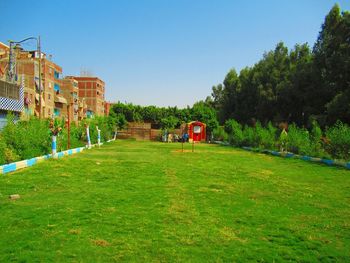 Built structure on field by trees against clear sky