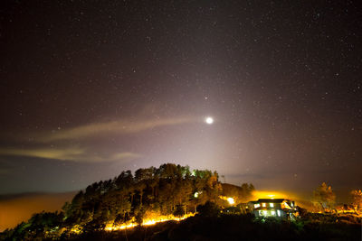 Low angle view of illuminated building against sky at night
