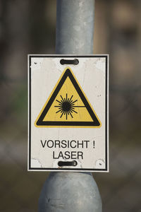 Close-up of warning sign on pole