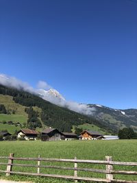 Scenic view of field and mountains against blue sky