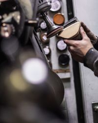 Cropped hands of worker making shoe in factory