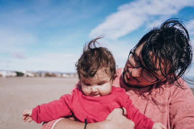 Portrait of mother and son against sky