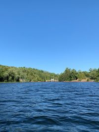 Scenic view of lake against clear blue sky