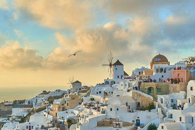 Buildings in town against sky during sunset