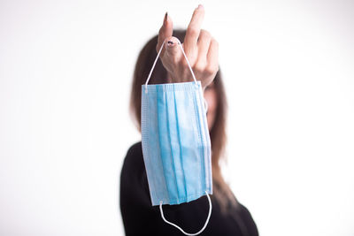 Midsection of person holding umbrella against white background