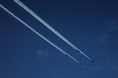 Low angle view of airshow against blue sky