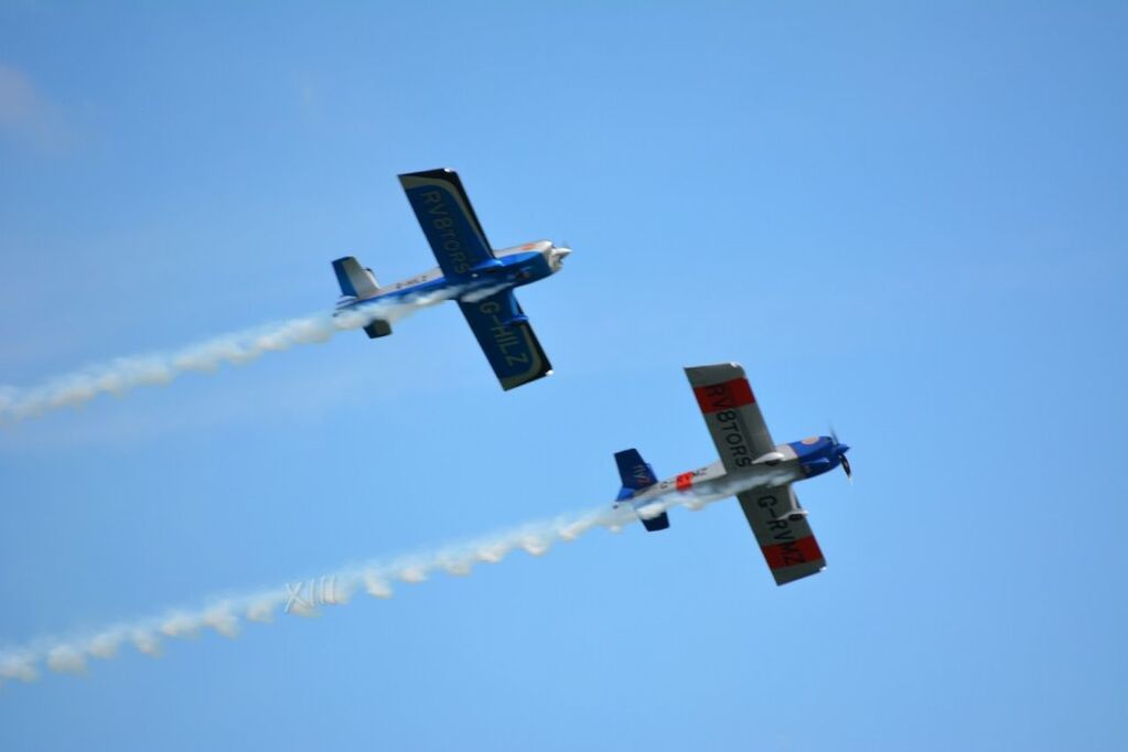 low angle view, flying, airplane, air vehicle, transportation, mid-air, mode of transport, blue, sky, clear sky, copy space, on the move, travel, outdoors, journey, fighter plane, aircraft, street light, military airplane, day