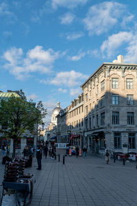 People on street against buildings in city