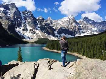 Woman standing on mountain against sky