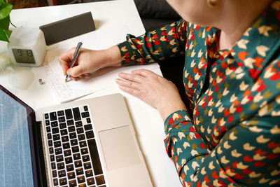 Female hand writing pen. unrecognizable elegant woman working on computer at office. start or finish